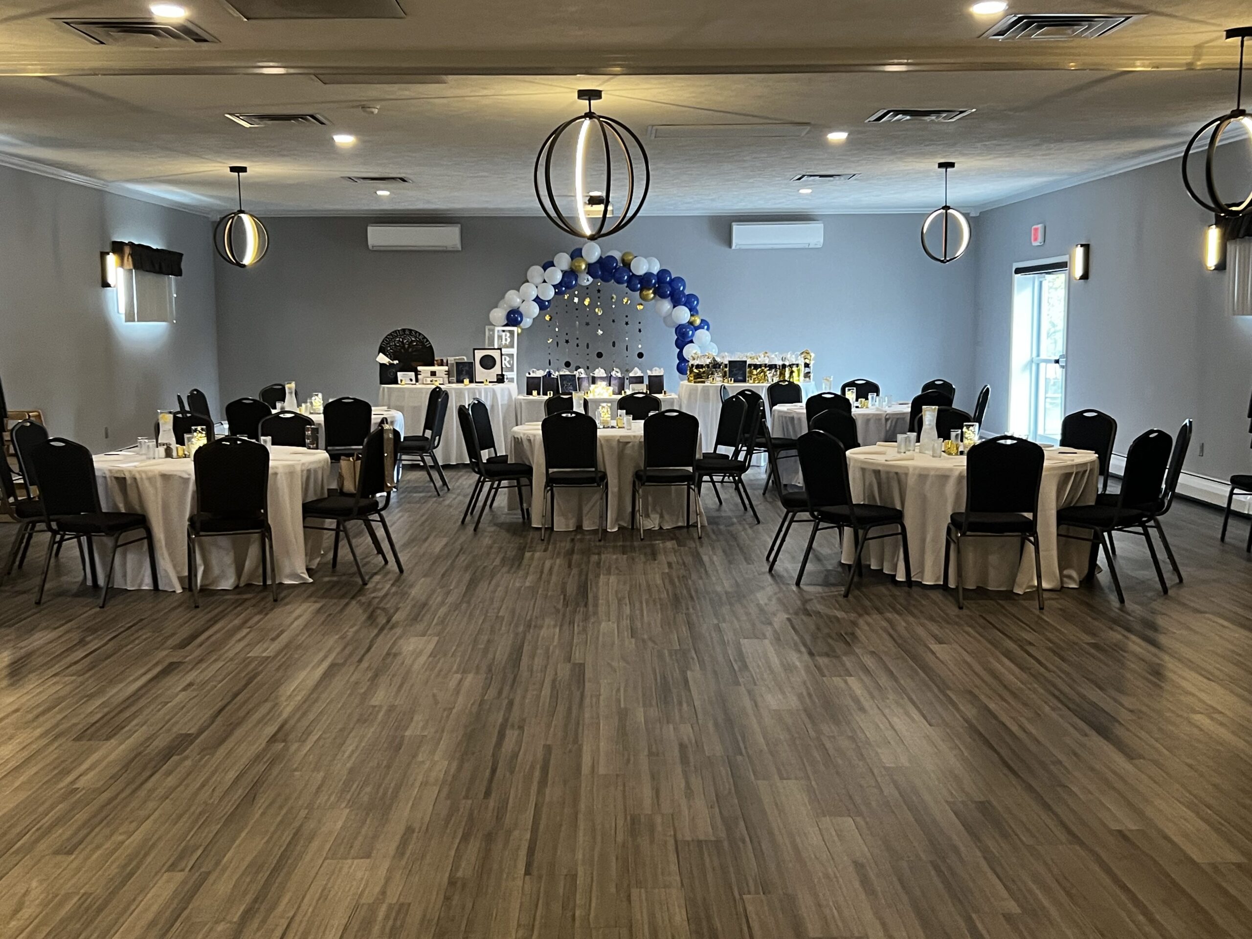 Large event hall with ash-wood floors set up for an event.